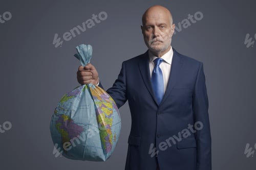 Preview: Businessman holding a polluted earth shaped as trash bag