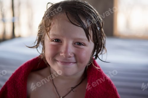 Preview: A five year old boy with wet hair and a red towel, smiling.