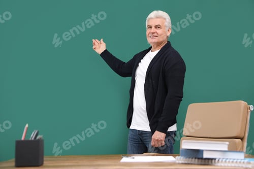 Preview: Portrait of senior teacher at green chalkboard and table