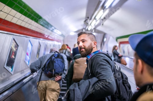 Preview: Hipster man standing at the escalator in London subway