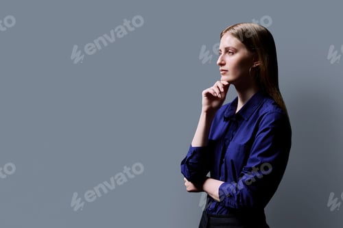 Preview: Profile view, confident young woman, copy space gray studio background