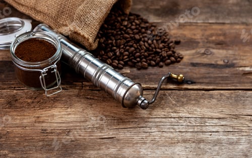 Preview: Bag of coffee on a wooden table. Coffee beans ground in a jar. Manual coffee grinder. Top view