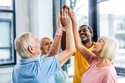 Preview: selective focus of happy senior multicultural sportspeople putting hands together at gym