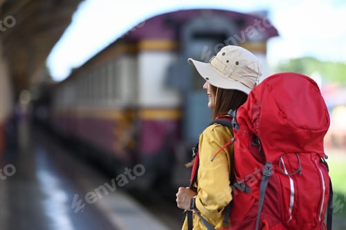 Preview: Young asian woman with backpack standing in train station.
