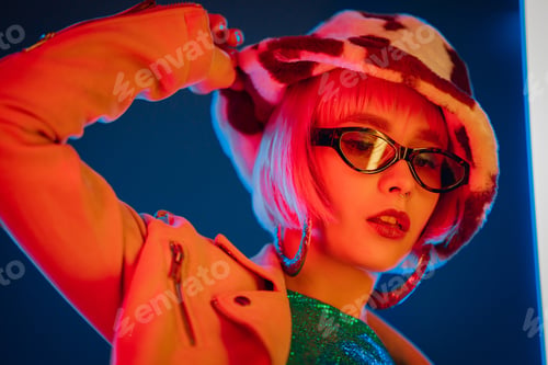 Preview: Portrait of glamorous woman on party under glowing neon light. Nightclub, trendy outfit. Teenager