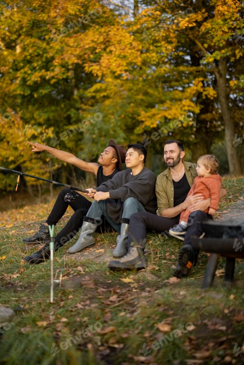 Preview: Male friends resting and fishing on lake coast