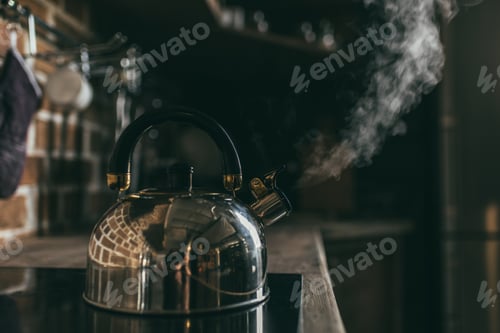 Preview: Close-up view of metallic kettle boiling on electric stove