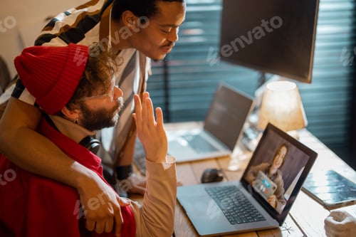 Preview: Stylish gay couple having video call with female colleague