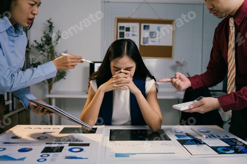 Preview: Asian businesspeople scolding a young businesswoman sitting at her desk with financial reports and p