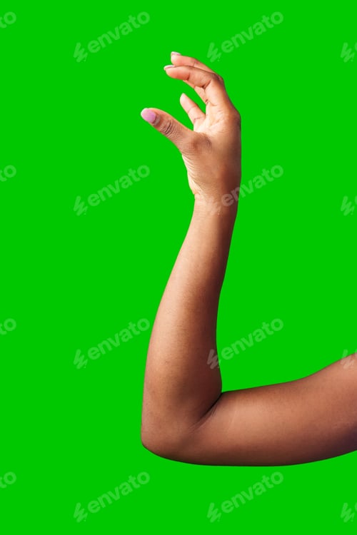 Preview: A hand making a gesture with a green background during daylight