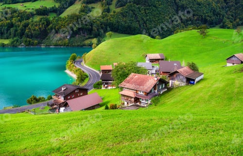 Preview: Lungern, canton of Obwalden, Switzerland. A view of rural homes in a green meadow.