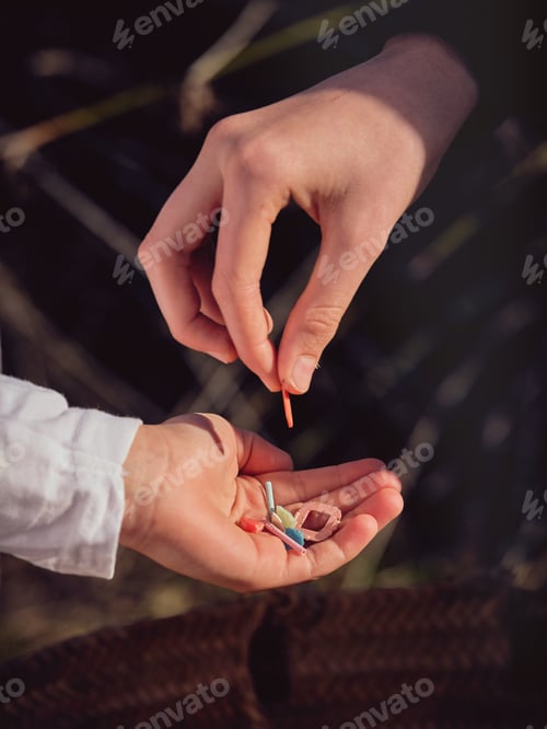 Preview: Crop person putting pieces of plastic in hand of boy