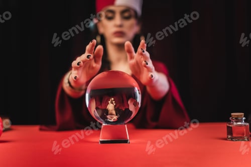 Preview: Magic orb near blurred fortune teller isolated on black