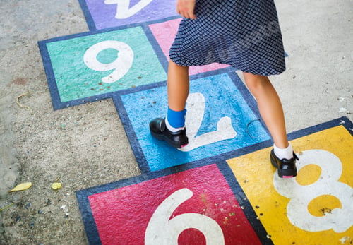 Preview: Young girl playing hopscotch