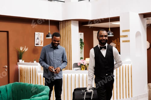 Preview: Hotel bellhop pulling guest suitcase
