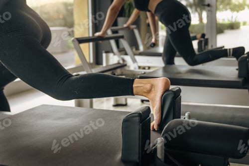 Preview: Women Exercising on Pilates Reformers in Modern Fitness Studio