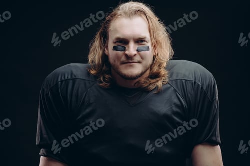 Preview: Determined American football player posing with painted face and chewing gum