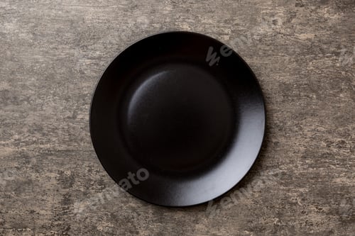 Preview: Top view of black plate on cement background. Empty space for your design