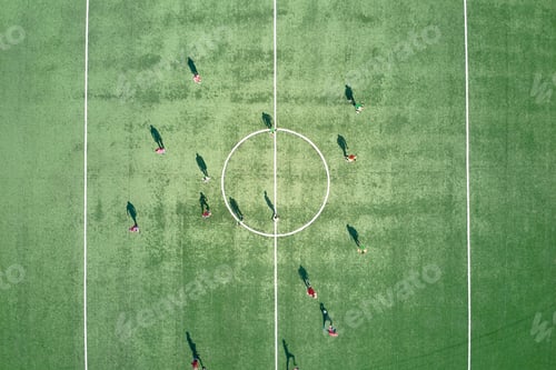 Preview: Aerial view of soccer players playing football on green sports stadium