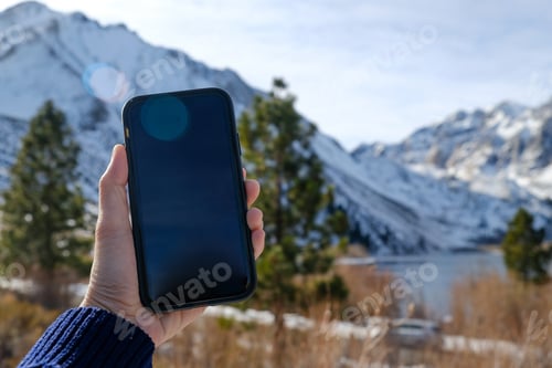 Preview: mobile phone and snow weather in the mountain.