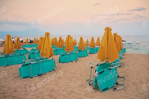 Preview: Collapsed deck chairs and umbrellas on the beach