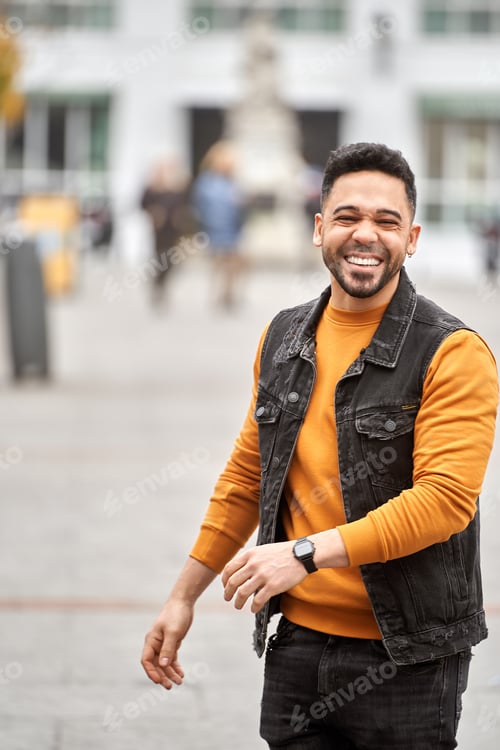 Preview: Man smiling while standing on the street.