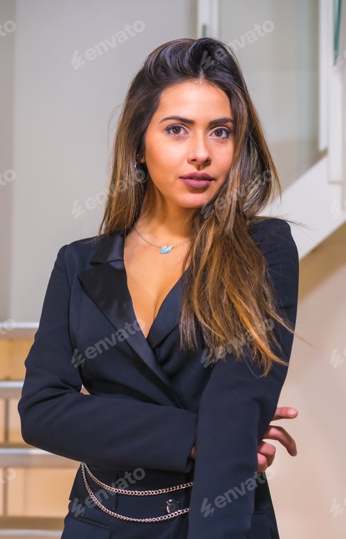 Preview: Caucasian girl in a black elegant suit posed on the stairs of a hotel, fashion photo