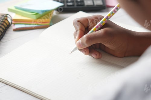 Preview: child girl hand writing on notepad.
