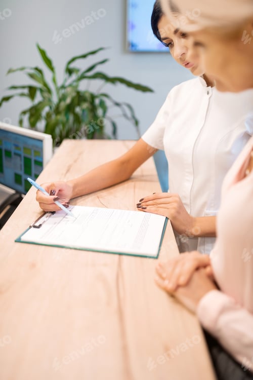Preview: Dentist helping her patient filling up the form