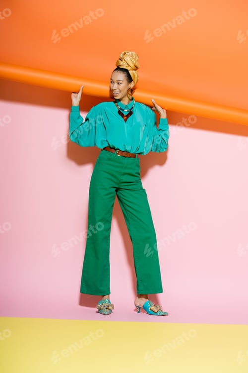 Preview: Full length of trendy african american woman in summer outfit smiling on colorful background