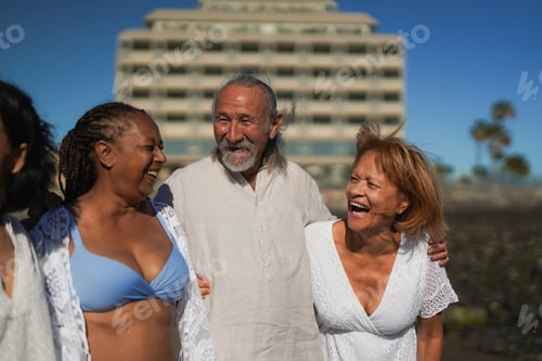 Preview: Happy multiracial senior friends having fun together on the beach during summer vacation