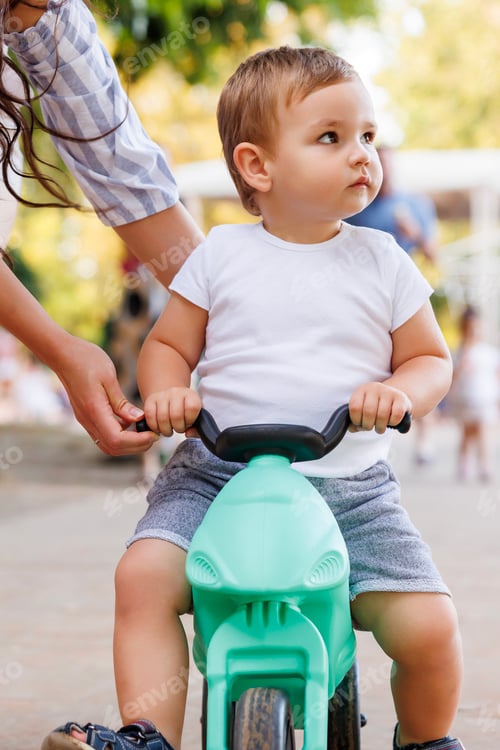 Preview: Mother helping baby to ride a bike