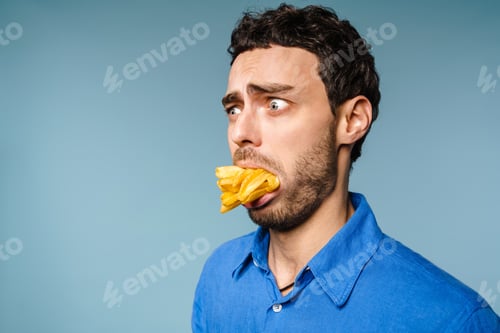 Preview: Shocked handsome guy posing with french fries in his mouth