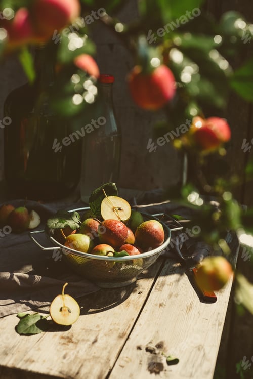 Preview: Many ripe pears in a colander on wooden garden table