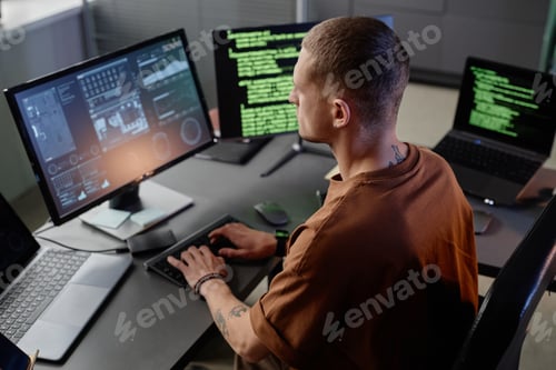 Preview: Male IT Developer Typing on Keyboard of Computer at Workstation Working in Office