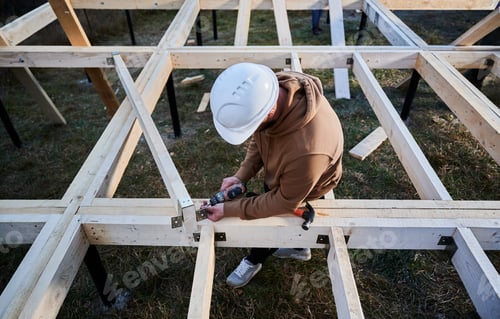 Preview: Man worker building wooden frame house on pile foundation.