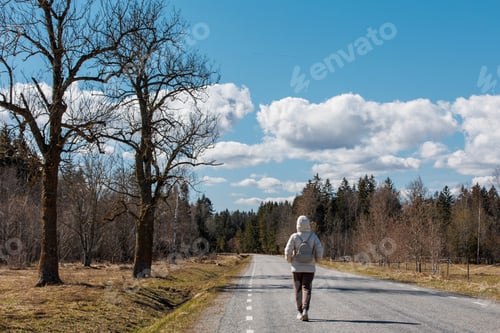 Preview: Woman traveling and walking in Road on background of beautiful sky, colorful of sky and forest.