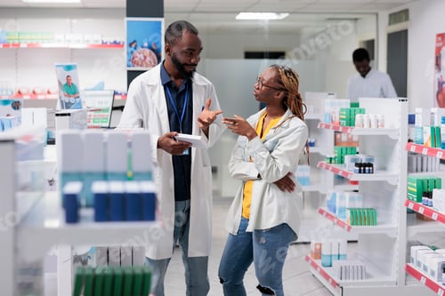 Preview: African american pharmacist and buyer discussing medicaments in drugstore