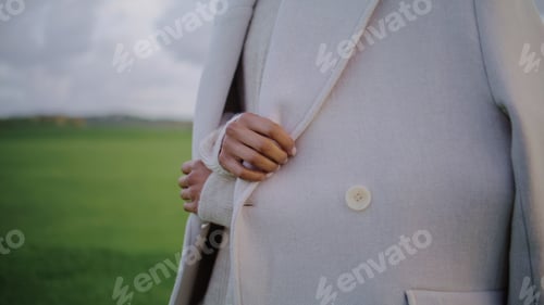 Preview: Hands touching autumn coat on cold weather closeup. Stylish woman adjust clothes