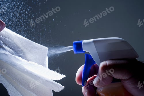 Preview: Cropped view of man spraying cleaning product of cloth