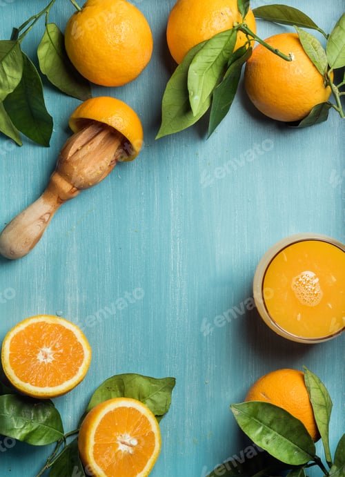 Preview: Fresh orange juice in glass and oranges with leaves on wooden turquoise blue painted background