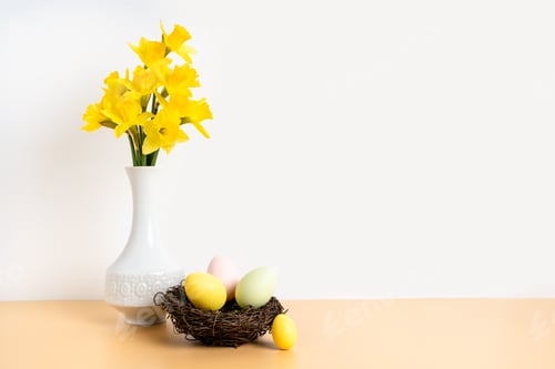 Preview: Colorful pastel easter eggs in nest and bouquet of daffodil flowers in white vase