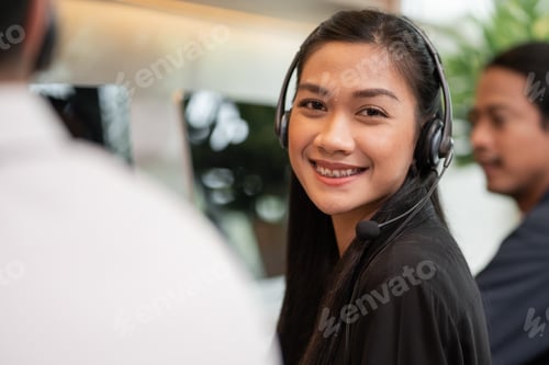 Preview: Asian female telemarketing agent looking at camera
