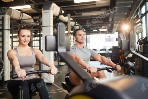 Preview: Sport Couple Using Exercise Machine in Gym