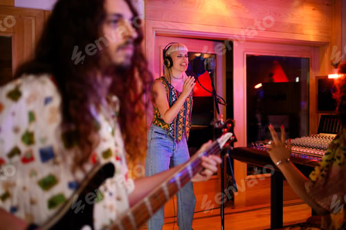 Preview: Bass player and singer recording a song in music studio.