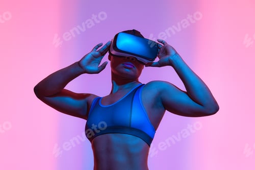 Preview: Modern african black woman with short hiar in sport top and leggings wearing glasses of virtual