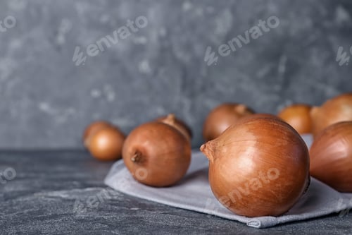 Preview: Fresh ripe onions on table against grey background