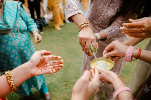 Preview: Close-up view of hands applying traditional henna decorations to the bride's hands