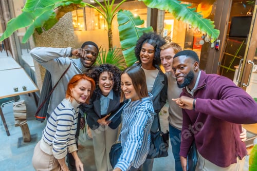 Preview: Coworkers gesturing and smiling while taking selfie together