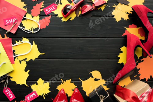 Preview: paper leaves, shopping bags, heels and sale tags on wooden tabletop with copy space